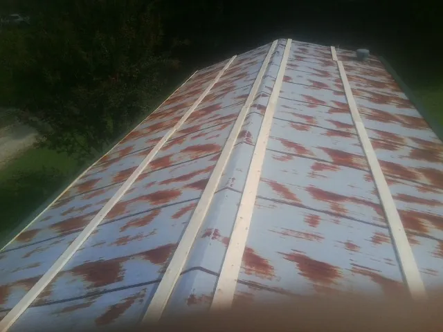 Rusted metal roof panels with new wood purlins before replacement — Storm Damage Roof Repair in Wilson by Roofing Brothers